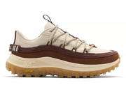 A single Vibram outdoor shoe shown in profile against a white background. The shoe features a cream and brown upper with matching brown laces, a thick cream midsole, and a brown Vibram outsole.
