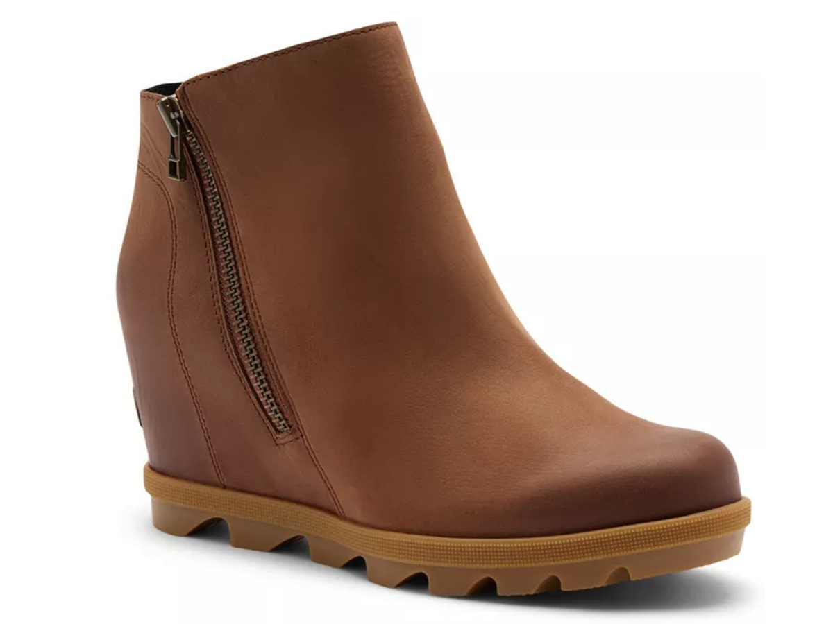 A brown leather wedge ankle boot with a side zipper and a chunky tan sole, shown from a three-quarters angle on a white background.