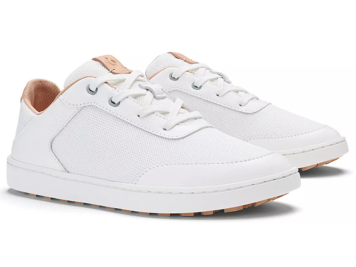 A pair of white low-top sneakers with white laces, white soles, and light tan leather accents on the tongue, heel tab, and outsole, shown against a plain white background.