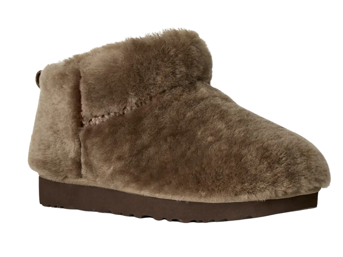 A single taupe brown faux fur slipper boot with a dark brown sole, shown from a side profile on a white background.