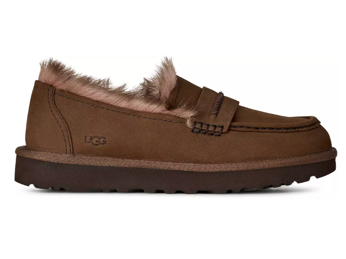 A brown suede UGG slip-on loafer with a soft tan shearling lining and a thick brown sole, shown in a side profile on a white background.