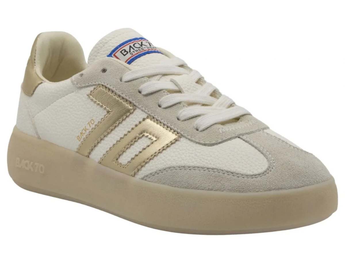 A Back To School low-top sneaker in off-white and beige suede, featuring metallic gold side stripes and a beige sole, shown on a white background.