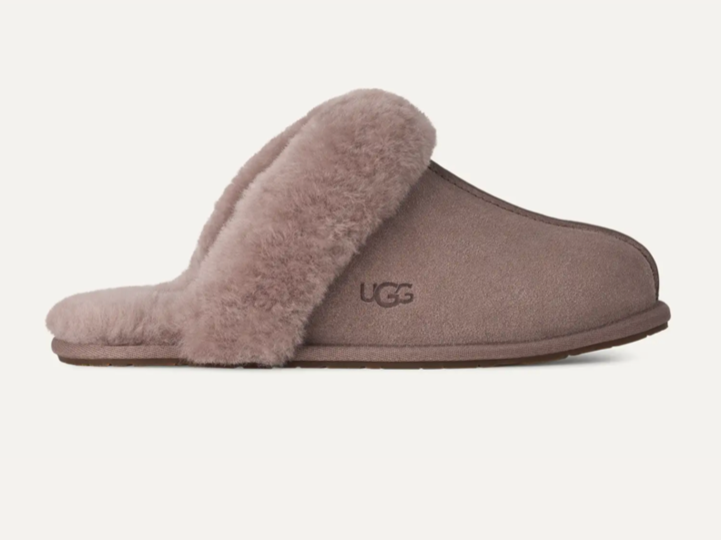 A single UGG slip-on slipper in taupe suede with a fluffy taupe shearling collar, shown from the side against a light off-white background.