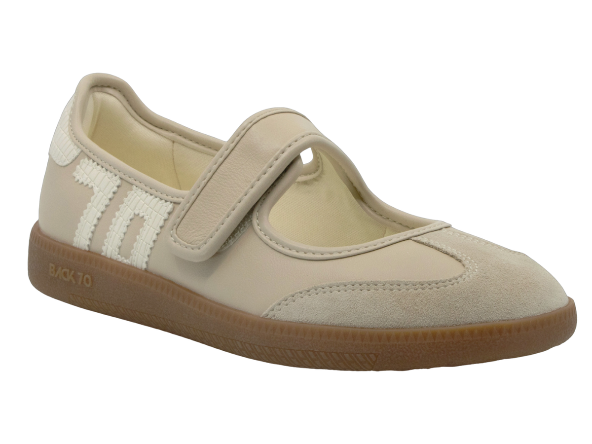 A single beige suede and canvas Mary Jane-style shoe with a hook-and-loop strap, white side stripes, and a brown gum sole, shown on a plain white background.