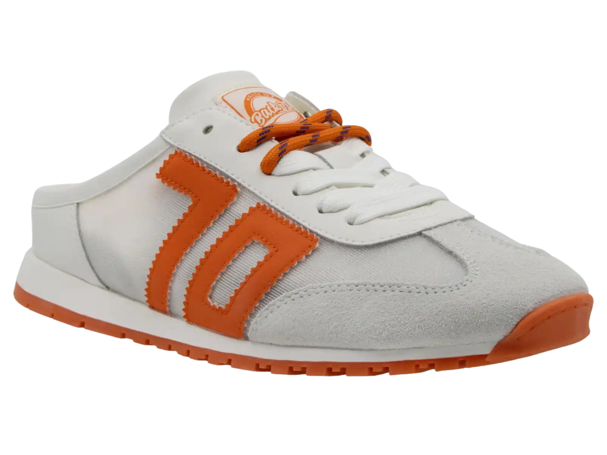 A white and orange low-top sneaker with a mesh side panel, suede overlays, orange laces, and a thick orange outsole.