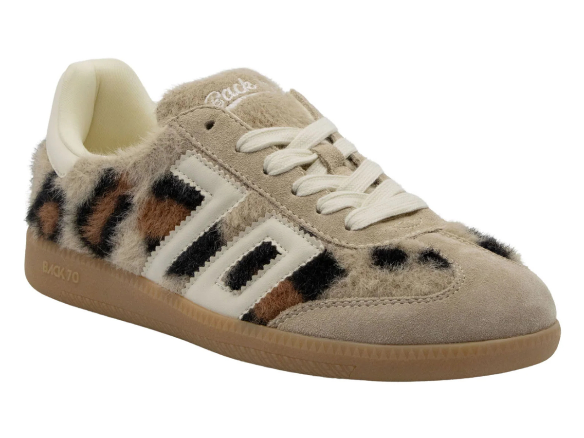 A low-top sneaker featuring a beige suede and fuzzy faux-fur upper with a brown, black, and beige leopard print pattern on the side stripes. It has white laces, a beige collar lining, and a gum brown sole.