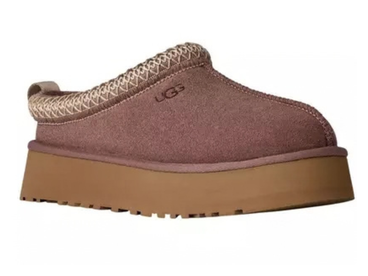 A single UGG slip-on clog shoe in a dusty mauve-brown suede with a tan platform sole and a beige braided trim at the opening, shown against a plain white background.